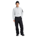 Front full body view of a man wearing the Burton AK Swash Gore-Tex 2L Snowboard Pants in Black with a white fleece top and black beanie