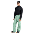 Front full body view of a man wearing the Burton AK Swash Gore-Tex 2L Snowboard Pants in Soft Sage with a blackfleece top and black beanie