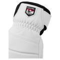White leather Hestra glove featuring a logo patch, elasticated wrist, and black cuff detail.
