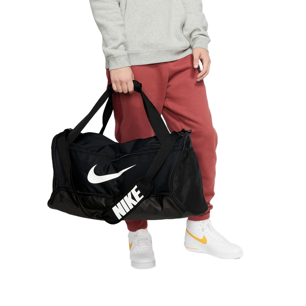 Cropped lifestyle image of Nike Brasilia Duffel in Black with brand logo in contrast White