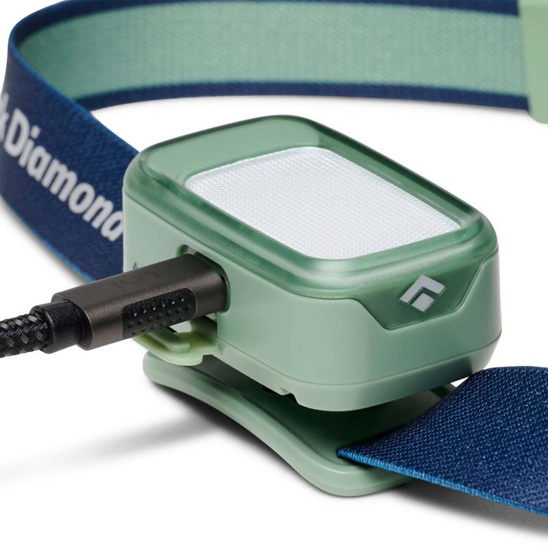 Black Diamond Wiz Kid Headlamp in sage green showing recharge cable into headlamp backing