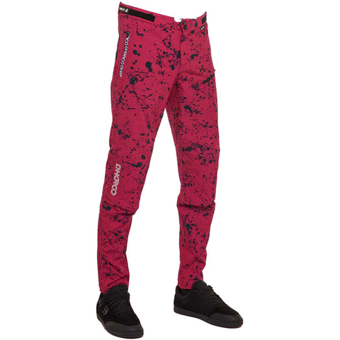 Men's mtb pants in pink/red with black splatter design.