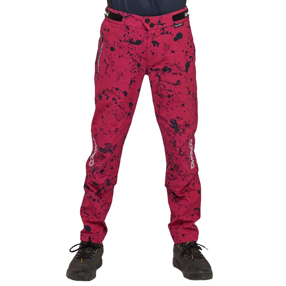 Youth mtb pants in pink/red with black splatter design.