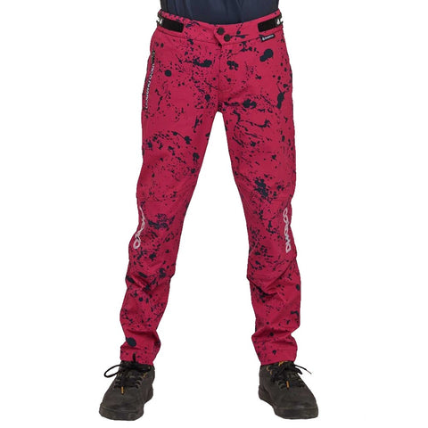 Youth mtb pants in pink/red with black splatter design.