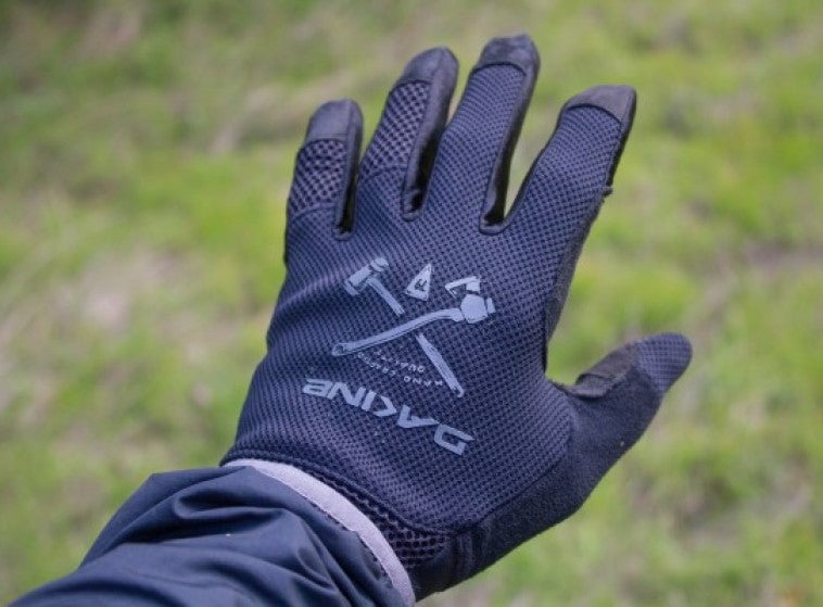 Dakine Covert bike glove featuring a tan and grey camouflage mesh back, black accents, and Dakine logo on the finger.