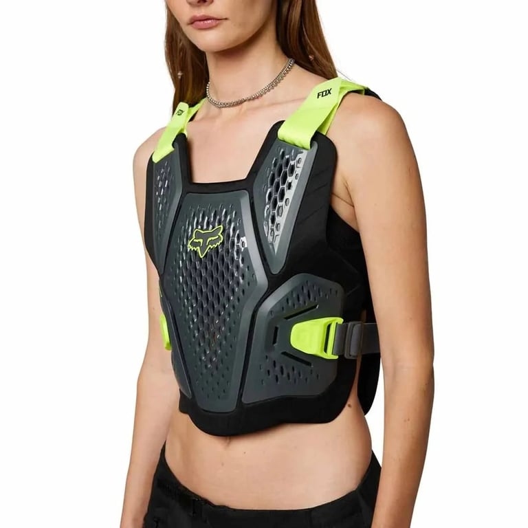 Black and grey Fox Raceframe Impact Guard with neon yellow straps and perforated chest panels on a model.