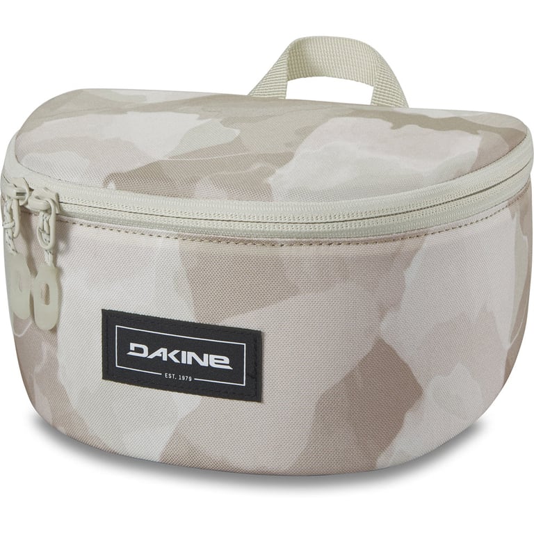 Tan camouflage Dakine Goggle Stash case with a semi-circular shape, double zipper, and top webbing loop.