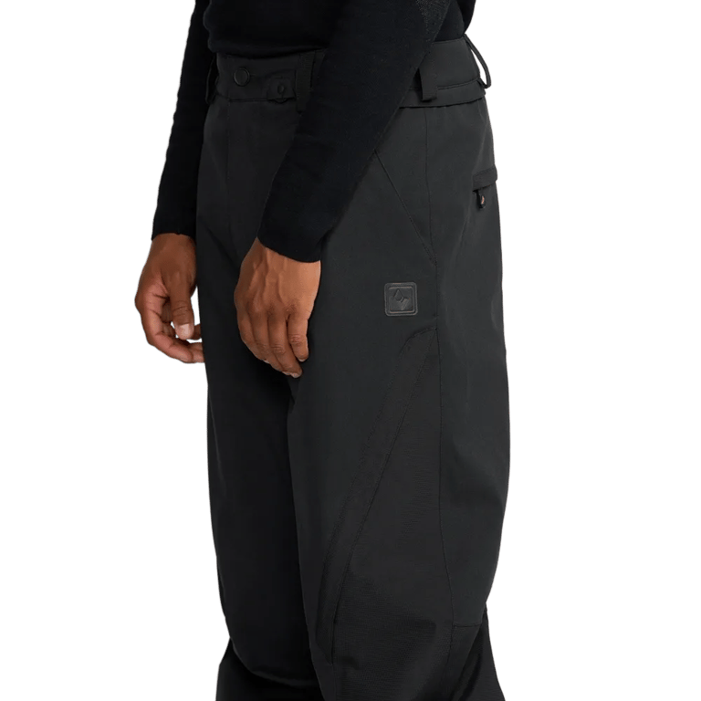 Side view of black Volcom Kleveland snowboard pants with a matte finish, belt loops, and a small logo patch on the thigh.