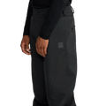 Side view of black Volcom Kleveland snowboard pants with a matte finish, belt loops, and a small logo patch on the thigh.