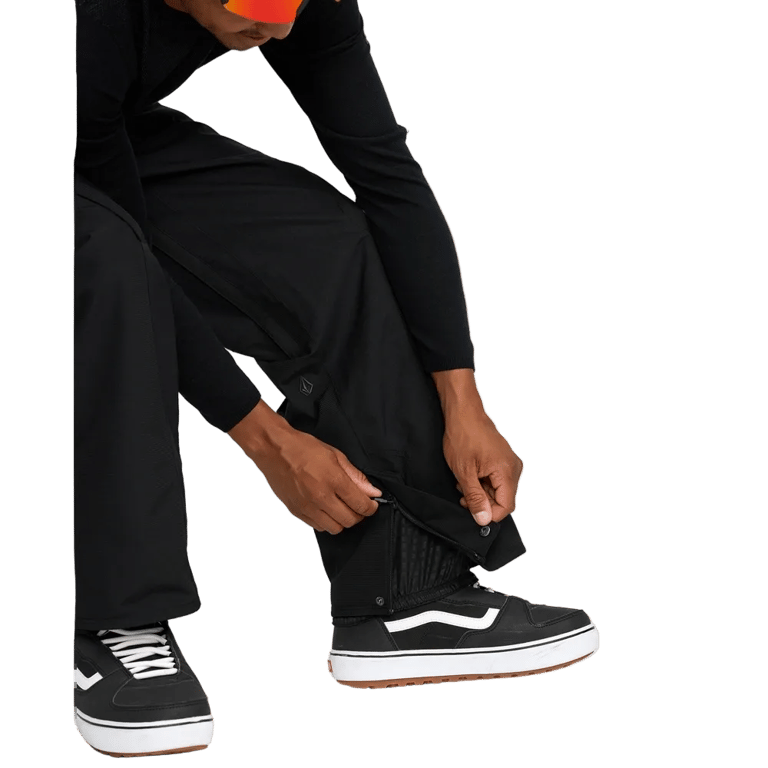 Volcom Kleveland black snowboard pants featuring adjustable snap and zipper cuffs with internal boot gaiters.