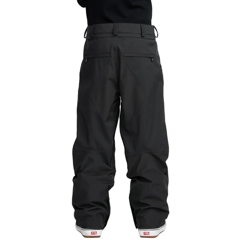 Rear view of black Volcom Kleveland snowboard pants with zippered back pockets and belt loops.