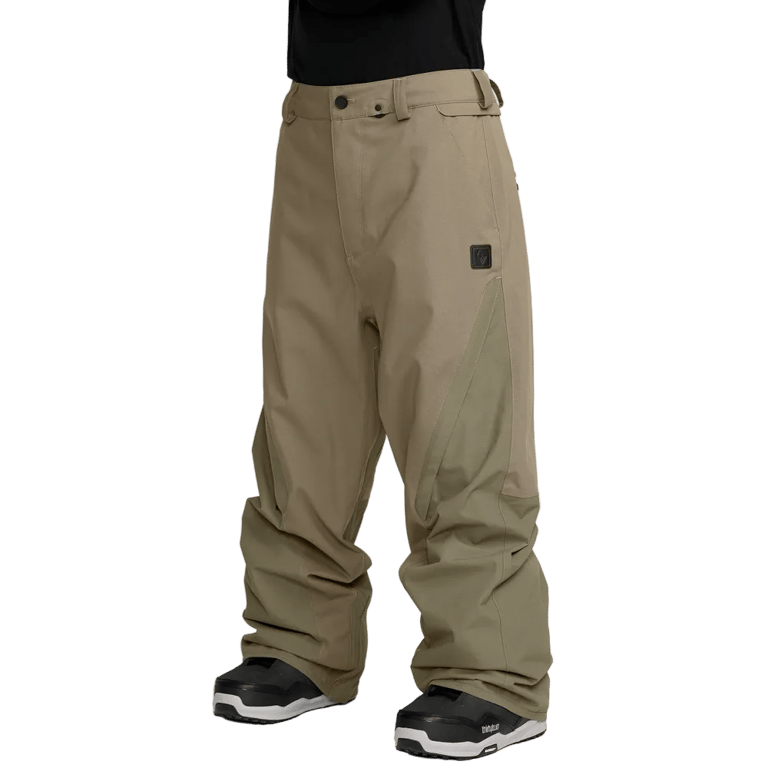 Tan Volcom Kleveland baggy snowboard pants with reinforced inner leg panels and a small black logo patch on the thigh.