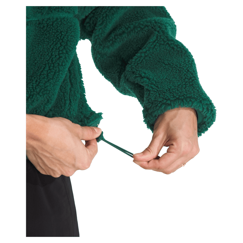 View of a woman wearing The North Face Extreme Pile 2 Pullover for Women in Hunter Green featuring side pockets and an adjustable hem