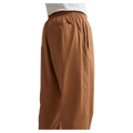 Detail view of the Nike Club Pants in Ale Brown colourway, unisex model