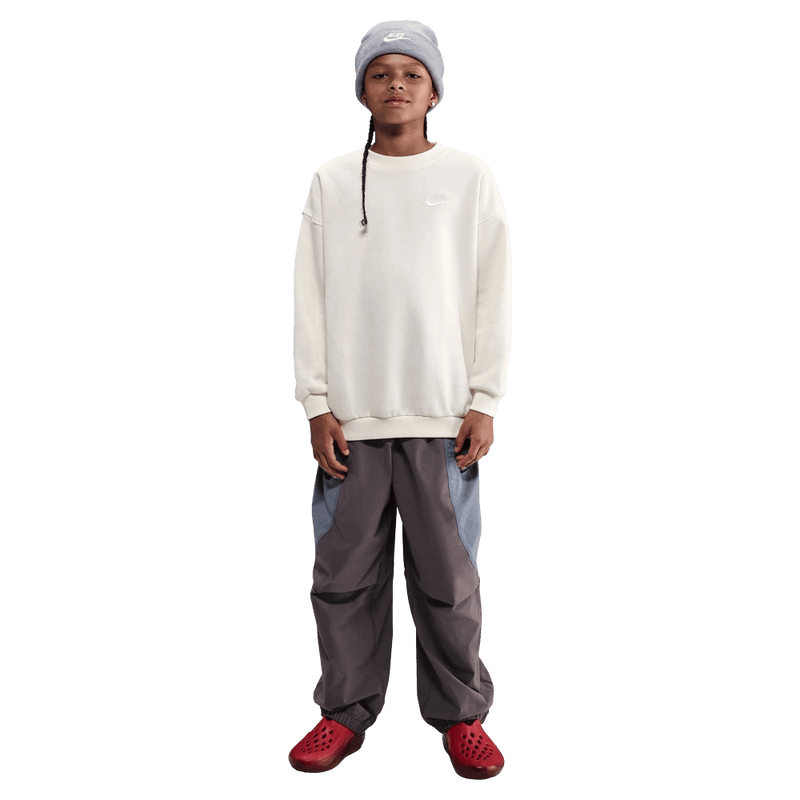 Front view of the Nike Sportswear Club Fleece Oversized Sweatshirt in Soft Pearl colourway, kids model