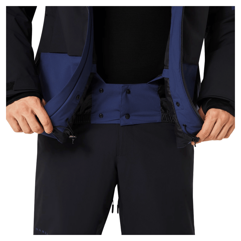 Powder skirt view of the Oakley Canopy Pro Insulated Ski Jacket in ABYSS and BLACK colourway, men's model