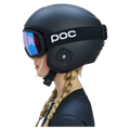 Side profile of a child wearing a matte black Poc Skull Dura Jr kids helmet and blue iridescent goggles.