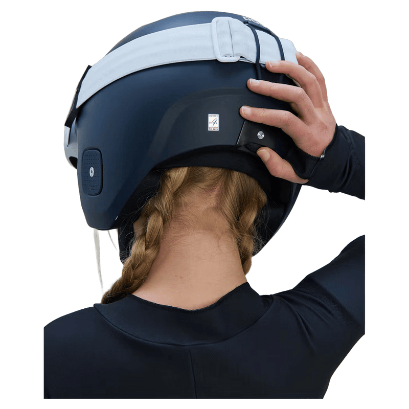 Rear view of a matte navy Poc Skull Dura Jr kids ski helmet with a white goggle strap and rear goggle clip.