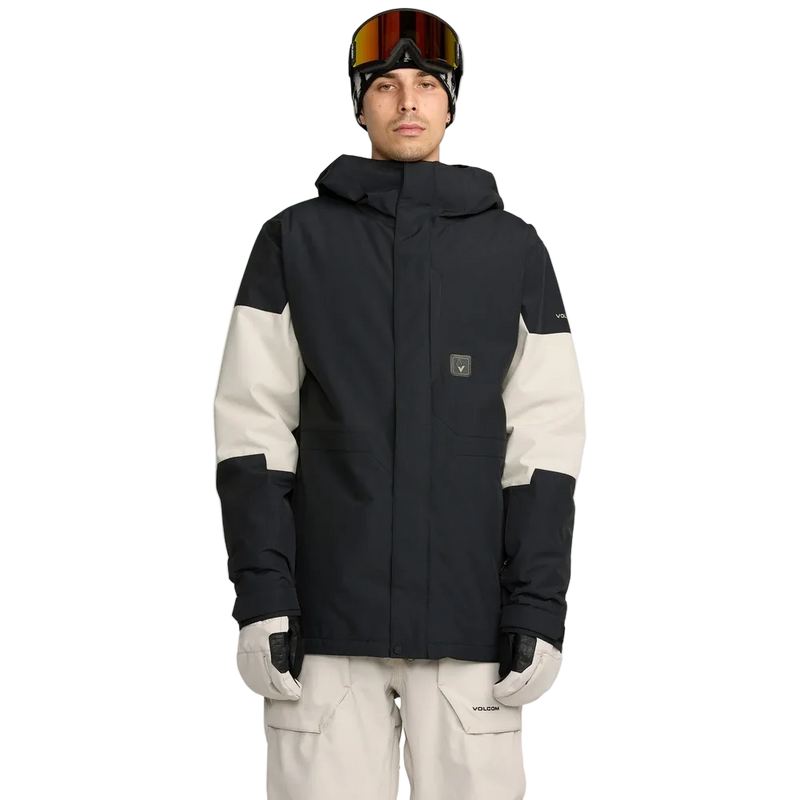 Front, on-body image of the Primry Snowboard Jacket in Black. Featuring a toggle cinched hood, covered placket, Velcro adjustable sleeve cuffs, chest pocket on the left, side pockets with zip closures. Two-tone colourway split with contrast Stone White across the elbows.