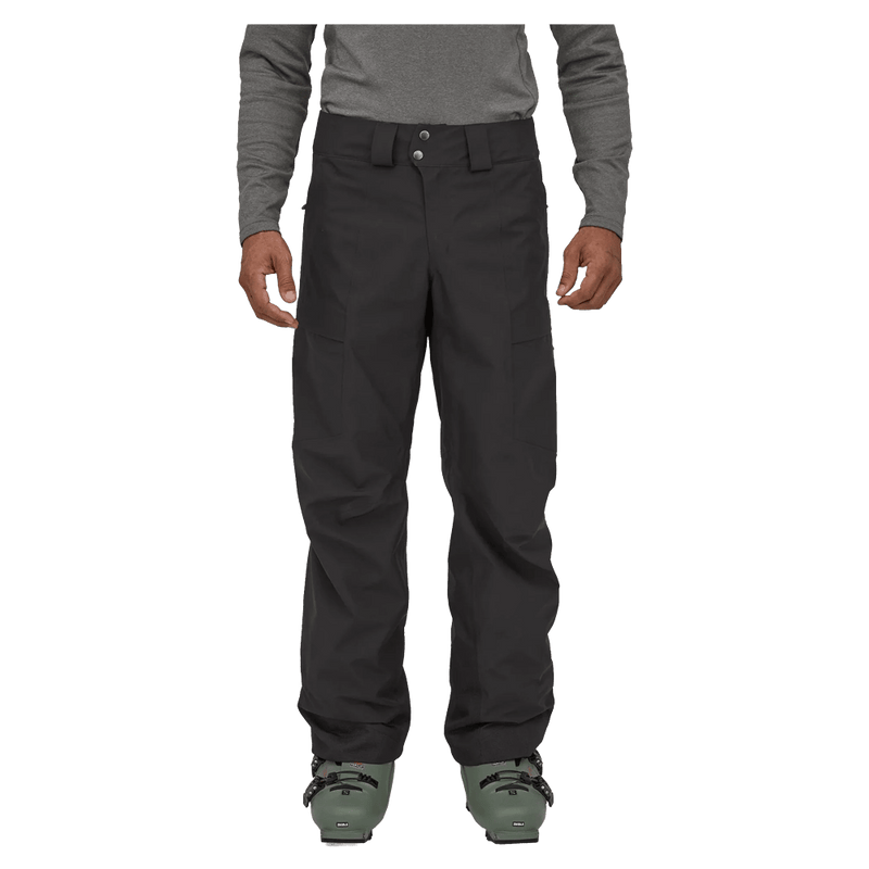 Black Patagonia Storm Shift Ski Pants with belt loops and snap closure, worn by a person with ski boots.