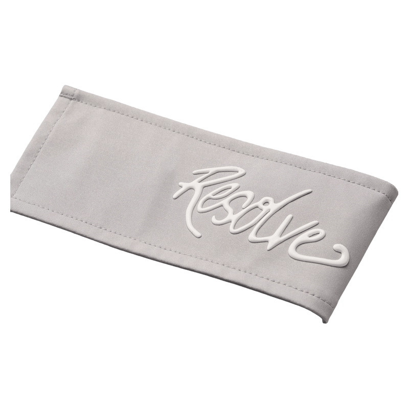 White raised cursive Resolve logo on a light grey stitched fabric panel of the Sprinter Baggy cargo Ski Pants.