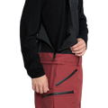 Detail, on-body image of the Rain Gore-Tex Bib Snowboard Pants from Volcom in Burnt Red. Featuring Neoprene Jersey at Side Waists with zip fastening.