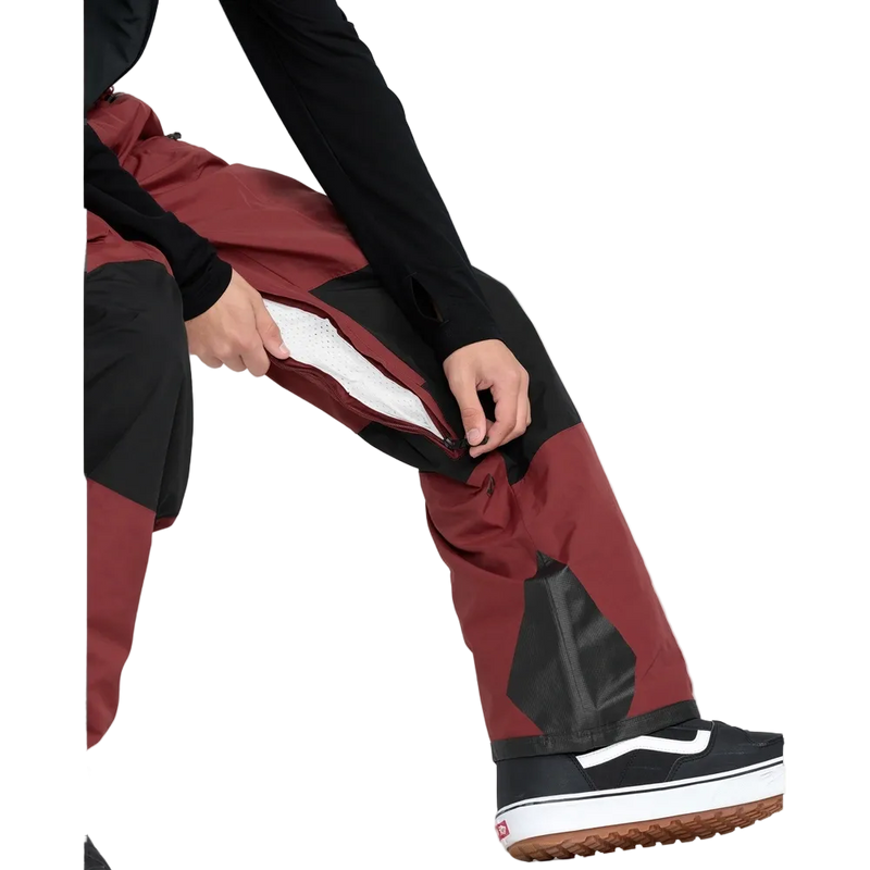 Detail, on-body image of the Rain Gore-Tex Bib Snowboard Pants from Volcom in Burnt Red. Featuring inner thigh vent with zip closure.