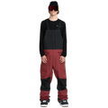 Front, on-body image of the Rain Gore-Tex Bib Snowboard Pants from Volcom in Burnt Red. Featuring adjustable shoulder straps, belt loops, ticket loop, side pockets with zip closure, and side cargo style pockets with zip closure. Contrast Black colour through upper bib and knee patches.