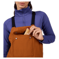 Chest pocket view of the Rossignol Outerlimits Insulated Bib in DEEP CARAMEL colourway, women model
