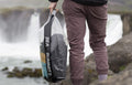 Model holding Sea To Summit Stopper Clear Dry Bag with articles inside
