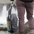 Model holding Sea To Summit Stopper Clear Dry Bag with articles inside