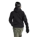 Rear view of a woman wearing the Sentinel Ski Jacket in Black featuring a helmet compatible hood.