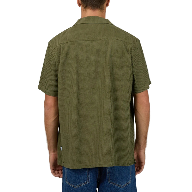 Back view of Man wearing Silent Theory's Conquor SS Shirt in olive colourway