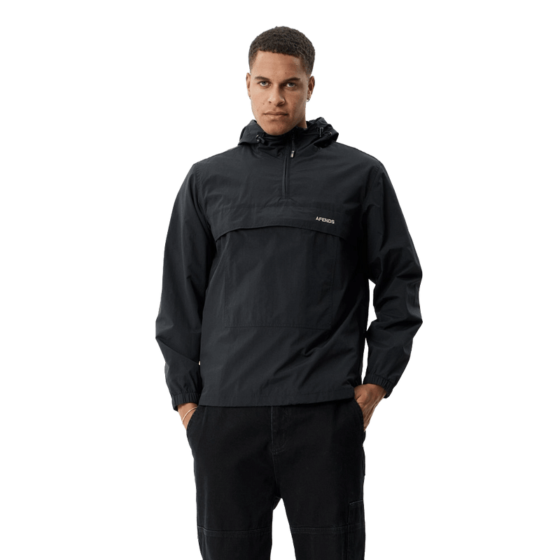 Black Afends hooded anorak jacket with quarter-zip and front flap pocket worn by a man, front view.