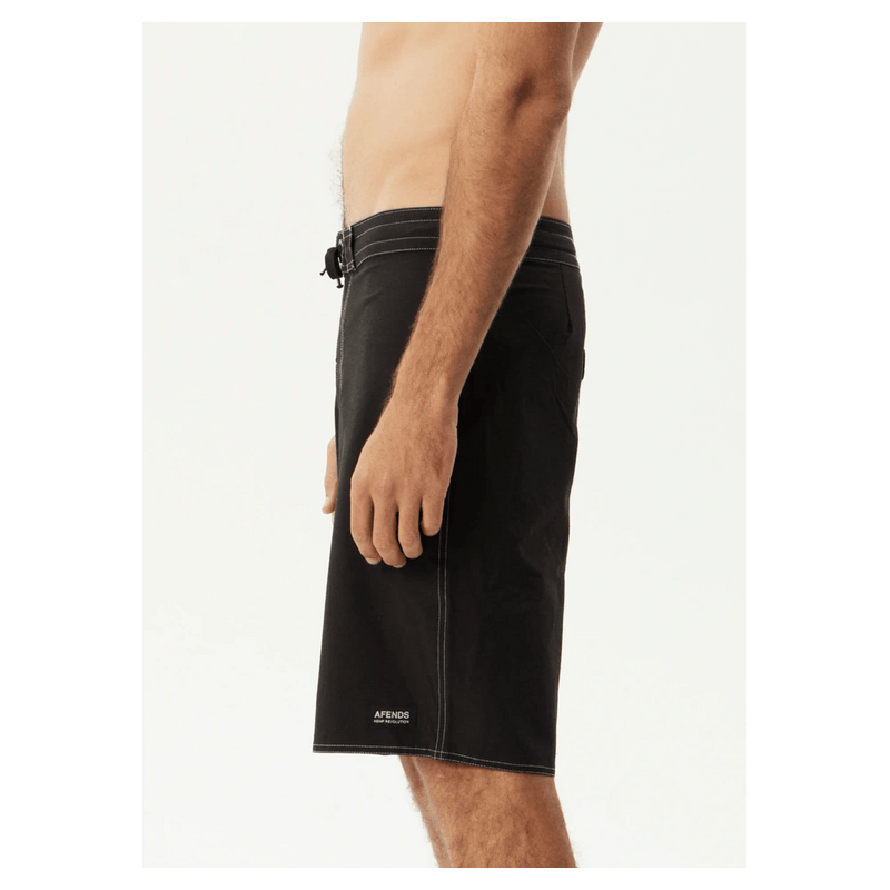 Side view of black Afends Surf Related V2 boardshorts with white contrast stitching and a fixed drawstring waist.