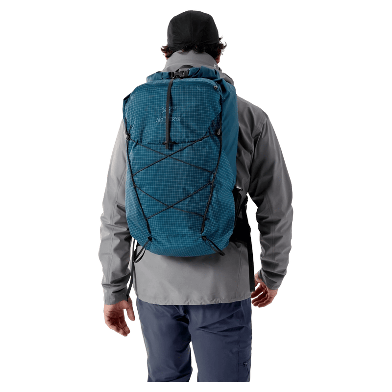 Blue Arcteryx Aerios 35 backpack with grid pattern and bungee cords, worn by a person from the back.