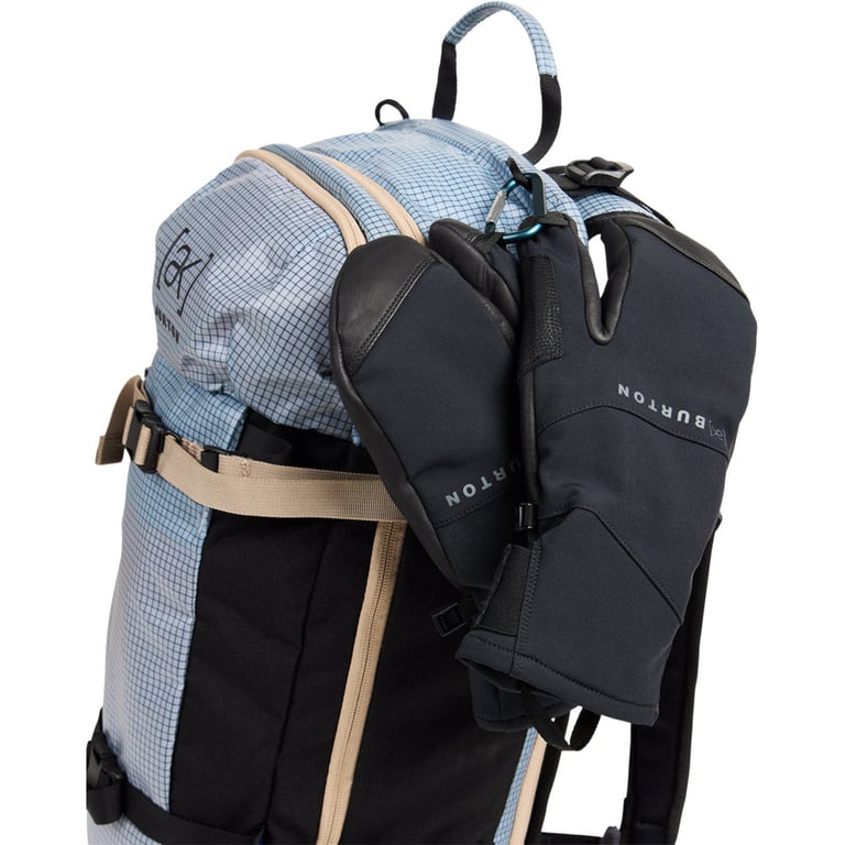 Black Burton AK Clutch Gore-Tex Mitts with leather palms clipped to a blue grid-patterned backpack.
