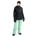 Black Burton AK Upshift Gore-Tex 2L women's snowboard jacket with hood and chest pocket, paired with mint green pants.