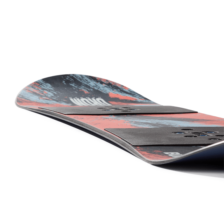 Low-angle view of a Burton Grom Camber kids' snowboard with red and blue abstract graphics and black binding plates.