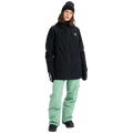 Woman wearing a black Burton Reserve Insulated Snowboard Jacket with a hood and mint green pants.
