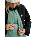 Black and green Burton Reserve Insulated Snowboard Jacket with a phone being placed in a zippered chest pocket.