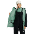 Woman wearing a black Burton Reserve Insulated Snowboard Jacket open to show mint green lining and interior powder skirt.