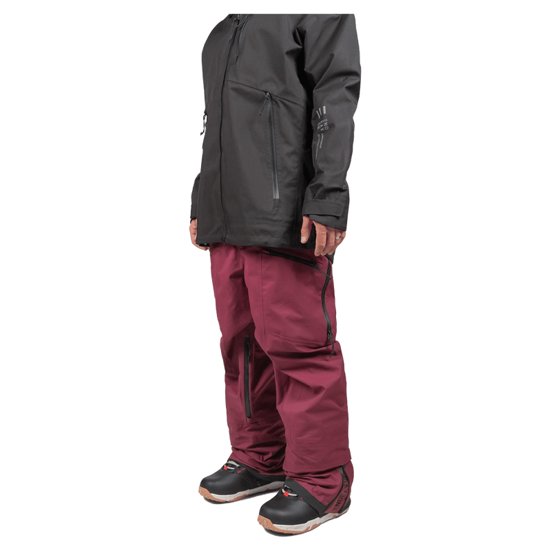 Endeavor 3L Shelter Bib Snowboard Pants in maroon with waterproof zippers, shown from a side profile on a person.