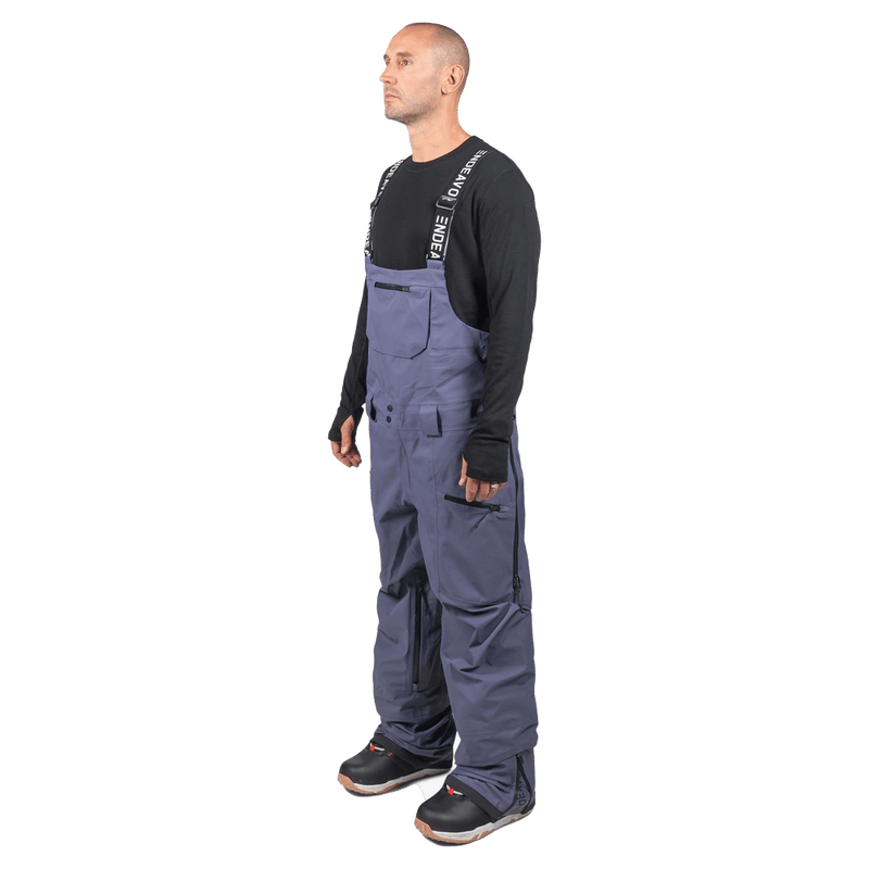 Side view of grey Endeavor 3L Shelter Bib Snowboard Pants with black branded straps and zippered pockets.
