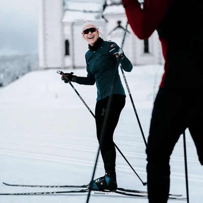 Woman cross-country skiing in blue and black Madshus Pulse Boa Skate Boots on a groomed snow trail.