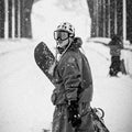 Modest Team XL Goggles with a large lens and branded strap worn by a snowboarder in a black and white snowy scene.