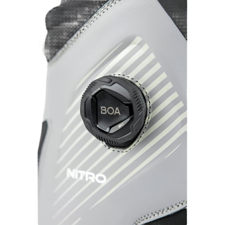 Close-up of the black BOA lacing system on a grey Nitro Club snowboard boot with white diagonal graphics.