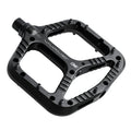 One Up Components Wave black flat mountain bike pedal with metal pins, textured surface, and white branding.