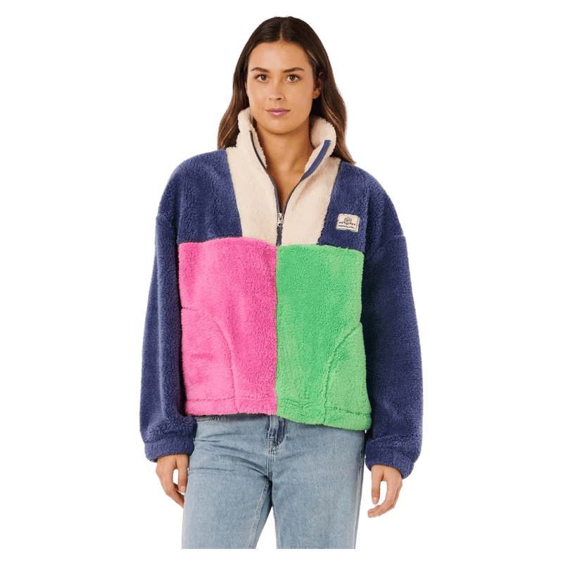Woman wearing a Rip Curl Block Party polar fleece with blue, pink, green, and cream color-blocked panels and quarter-zip.