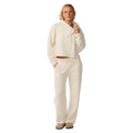 Woman wearing a cream Rip Curl Cala Nights textured cropped hoodie and matching wide-leg pants.